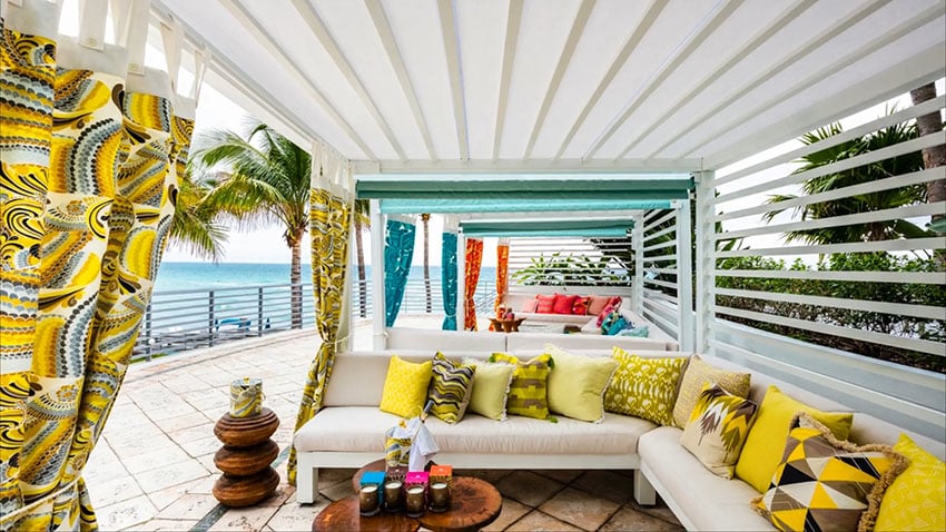 Oceanfront cabana with colorful decor and curtains