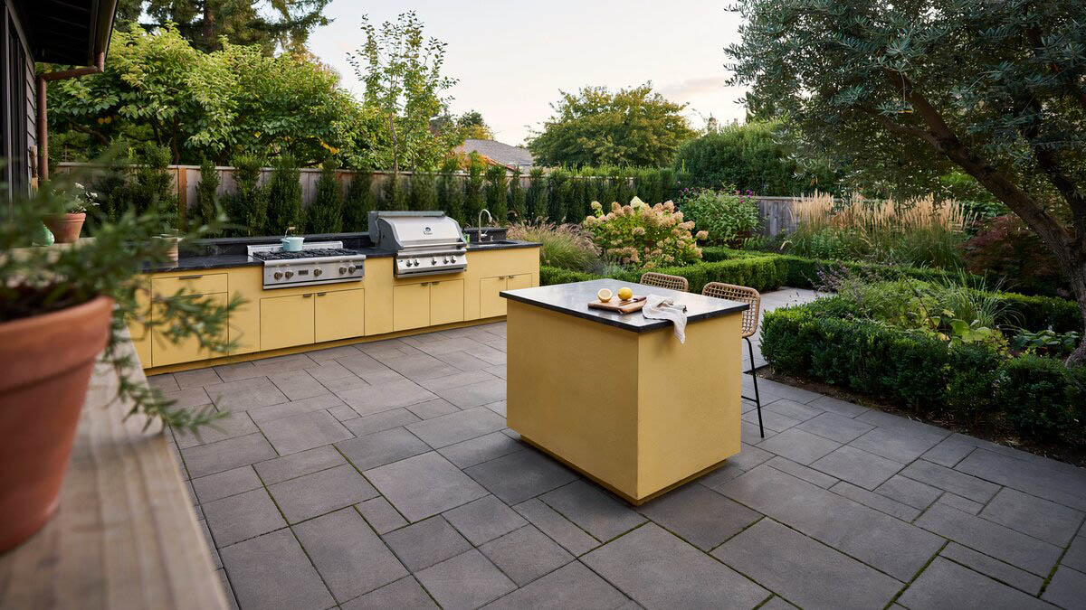 Yellow concrete garden kitchen with black granite counters and a built-in grill