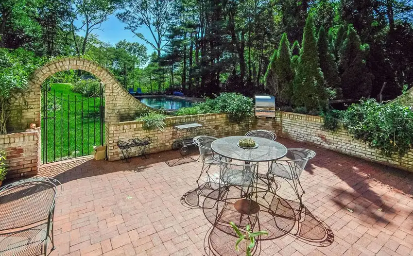 Paver patio with stone fence with wrought iron gate