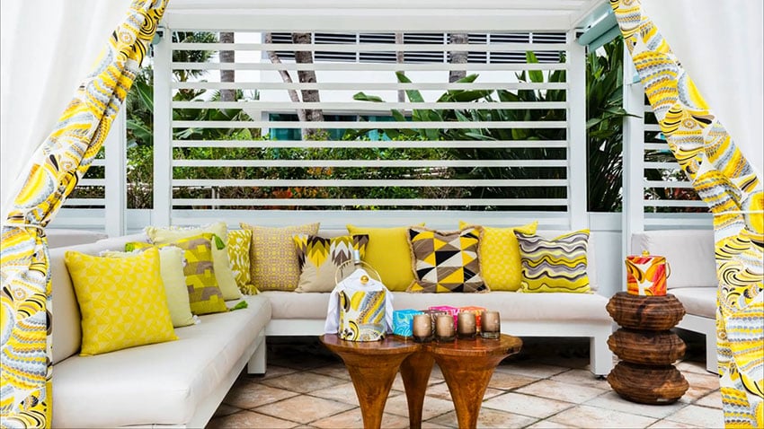 Pool cabana with yellow cushions and curtains