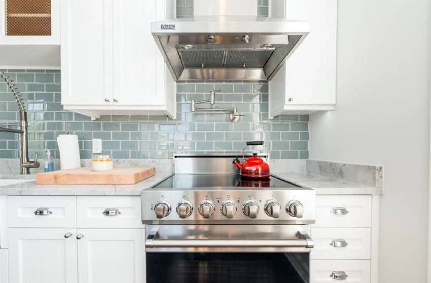 Small cottage kitchen with white recessed panel cabinets and aqua subway tile