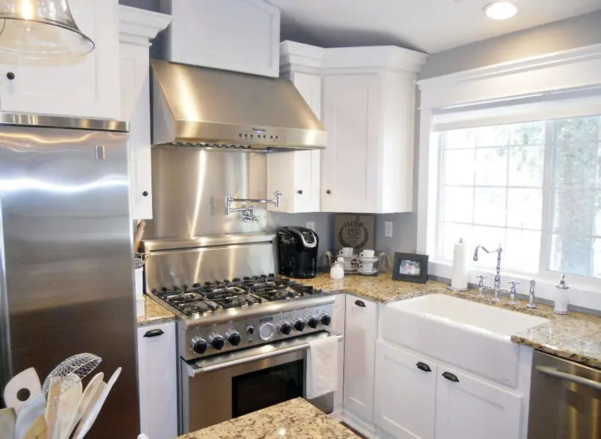 Kitchen with moldings, apron ceramic sink and steel range hood