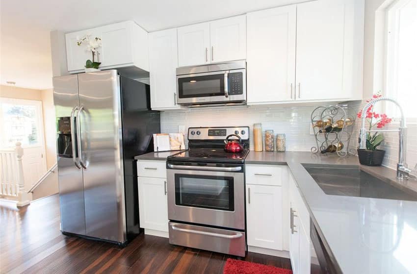 Small kitchen with white thermofoil cabinets and gray quartz countertops