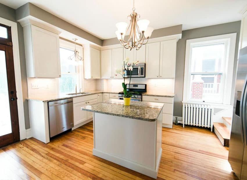 L-shaped kitchen with pine wood flooring with gray walls and small island