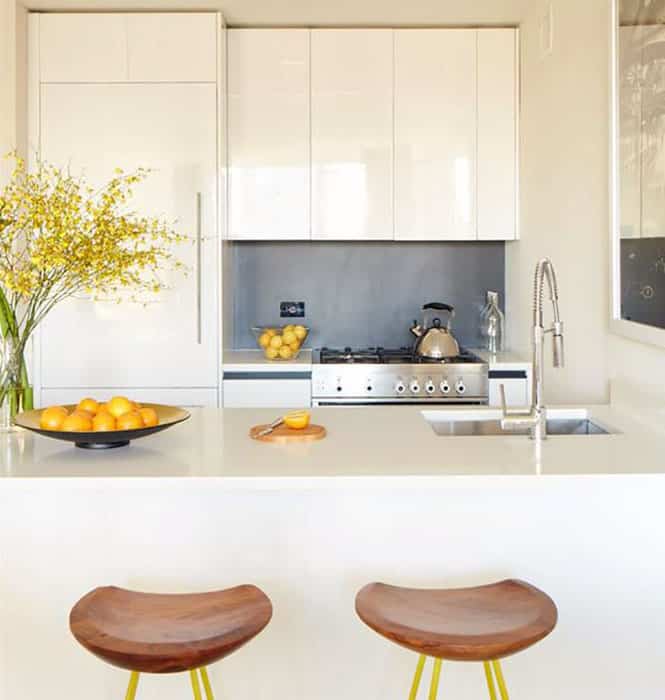Small modern kitchen with high gloss white cabinets and quartz counter peninsula with seating