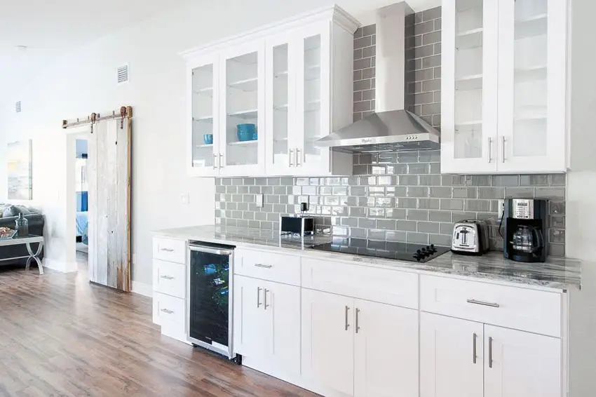 One wall kitchen with several cabinets and gray tiles as backsplash