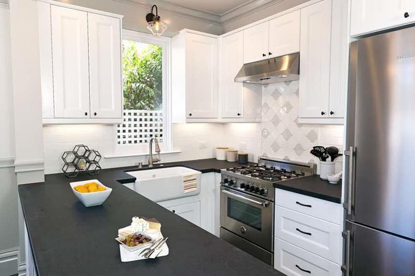 Kitchen with black soapstone counters, window and farmhouse style sink