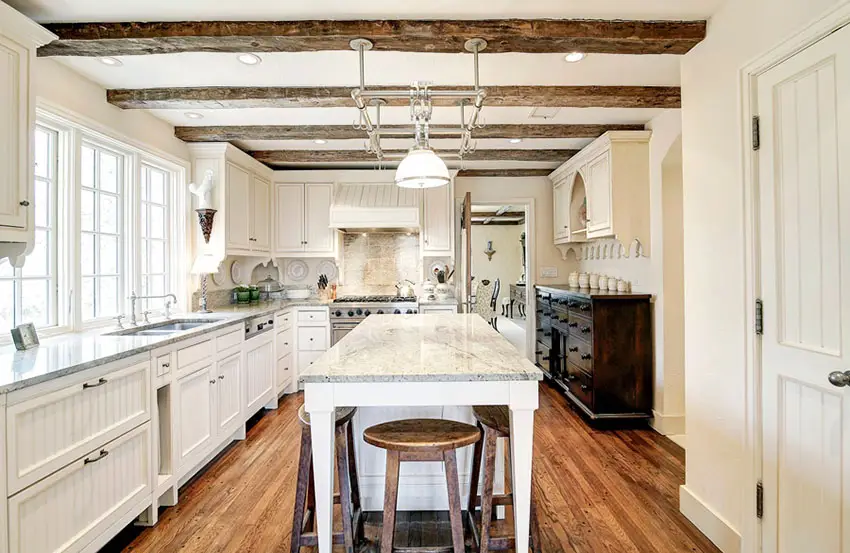 Traditional kitchen with white cabinets wood flooring and picture windows