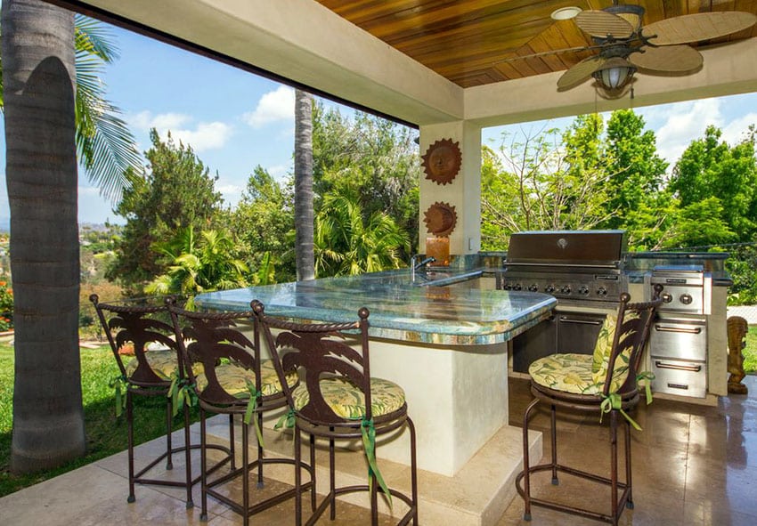 Tropical outdoor kitchen with granite counter peninsula bar