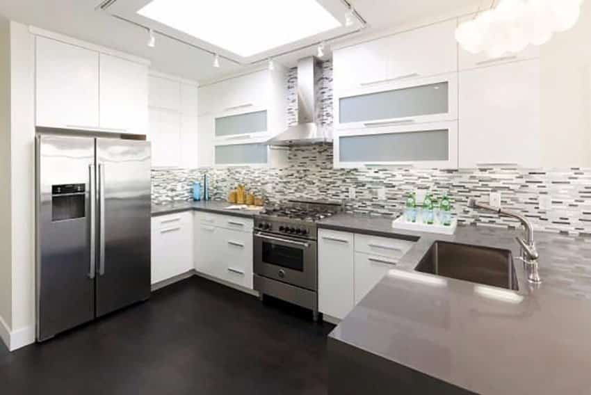 U shaped contemporary kitchen with white custom cabinets and gray corian countertops