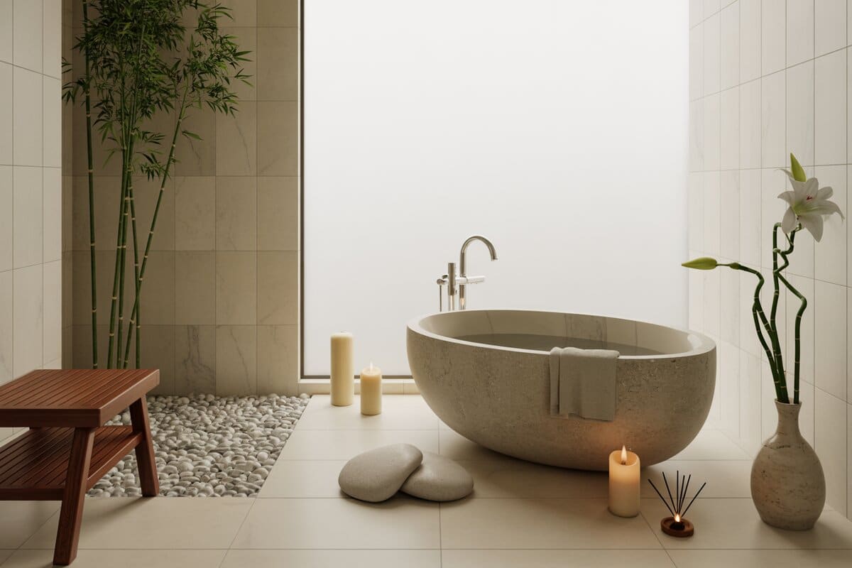 Zen bathroom with stone soaking tub, pebble floor strip, bamboo and lit candles