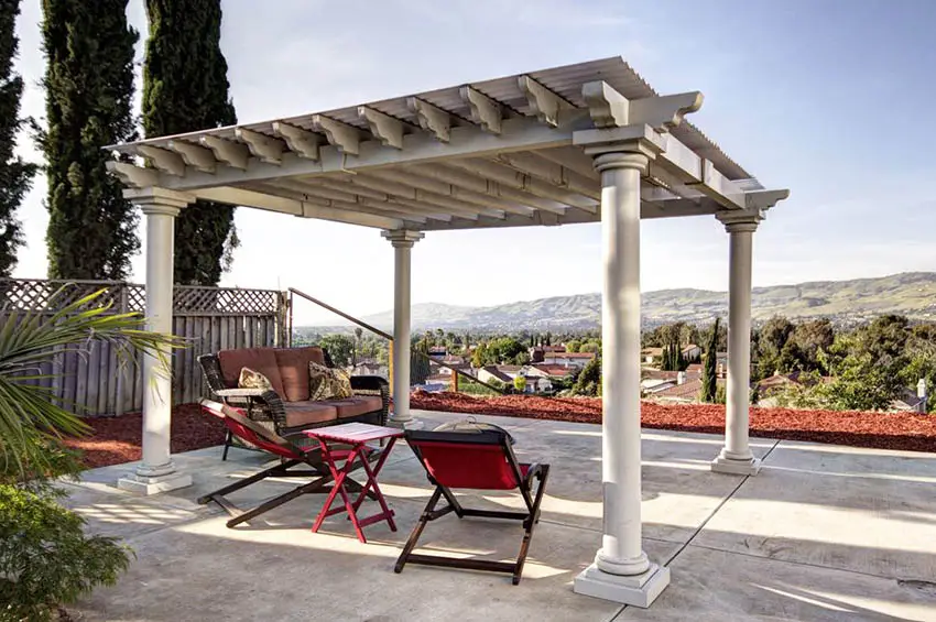 Backyard concrete patio with covered wood pergola with cement pillar supports