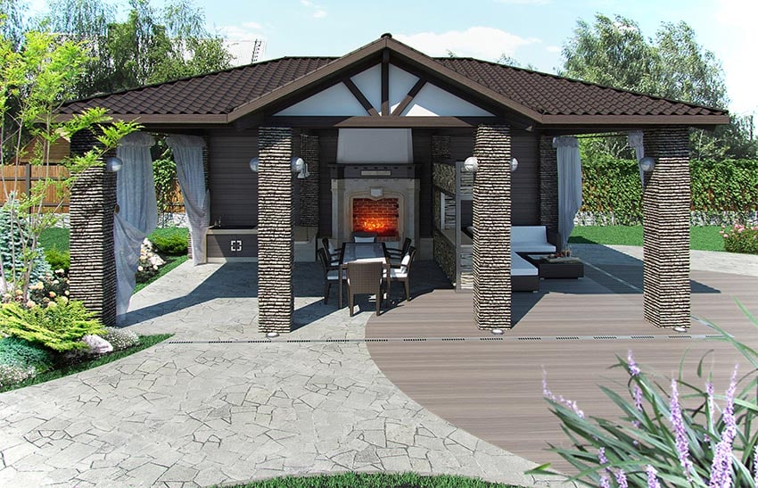 Backyard flagstone patio with wood deck and large outdoor structure with fireplace