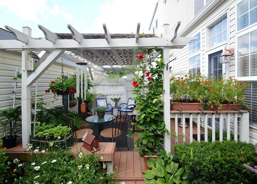 Backyard pergola with white fence and box planters