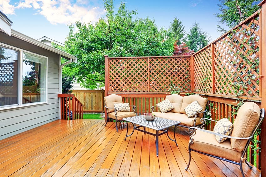 Backyard wood deck with lattice privacy fence and outdoor furniture