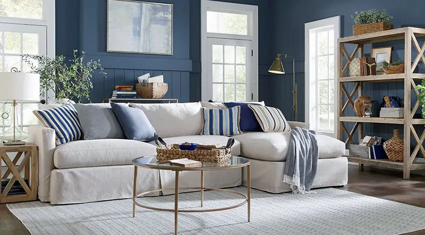 Coastal style living room with sectional couch and blue walls with wainscoting