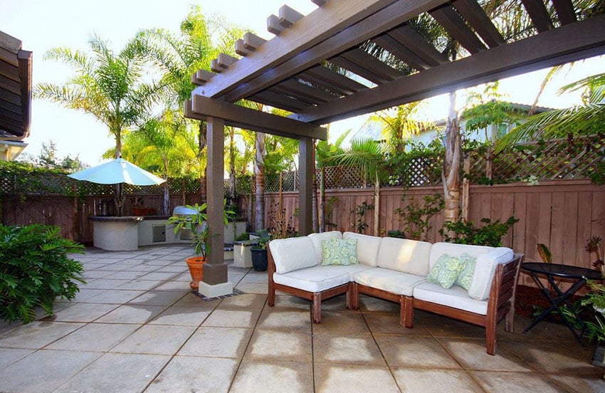 Gorgeous patio with wood pergola, wood fence with lattice top and outdoor kitchen