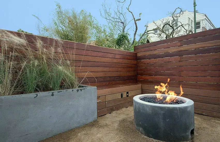 Concrete planter next to fence made of wood