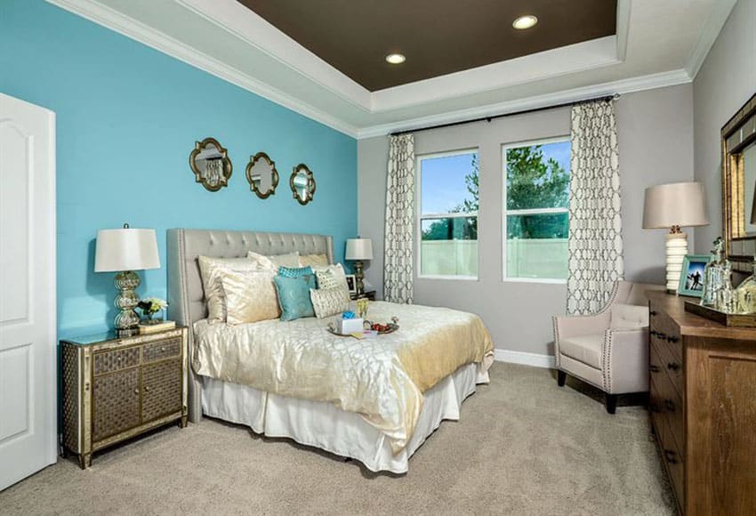 Contemporary bedroom with bright blue accent wall above bed brown painted tray ceiling and white molding