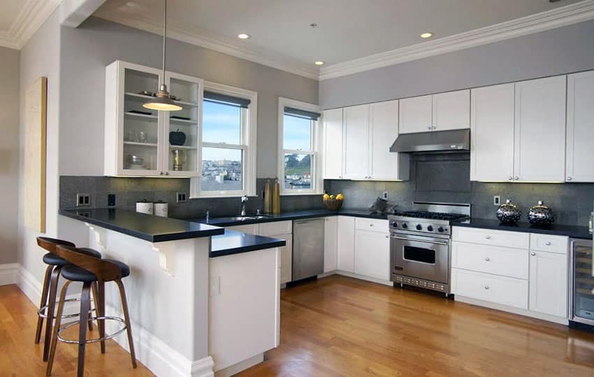 Contemporary kitchen with white cabinets and black pearl granite countertops and gray wall paint