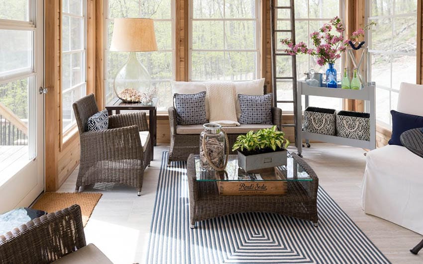 Country sunroom with wicker chairs and area rug