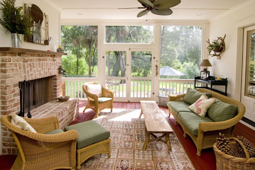Cozy sunroom with brick fireplace and wicker furniture