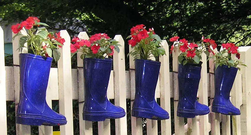 Decorative rubber boot flower planter on fence