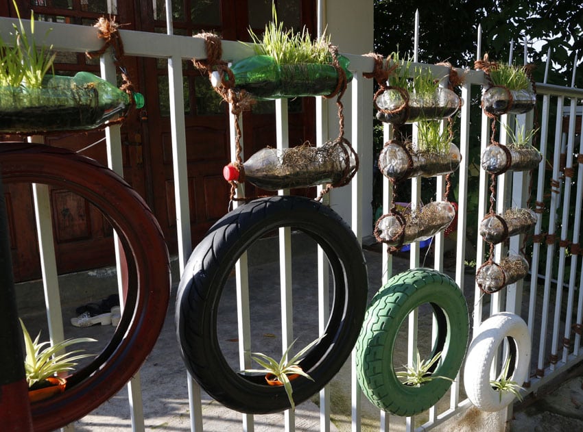 DIY hanging plastic bottle planters on fence with herbs