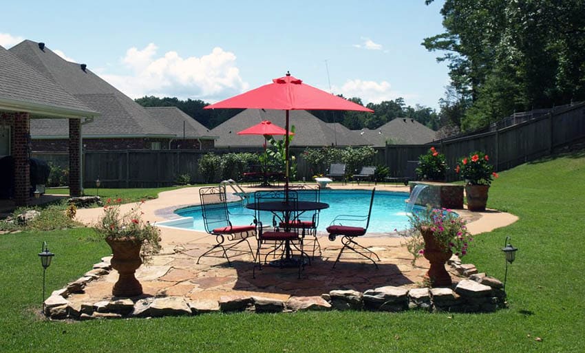 Pool area with natural rough stone borders and patio flags