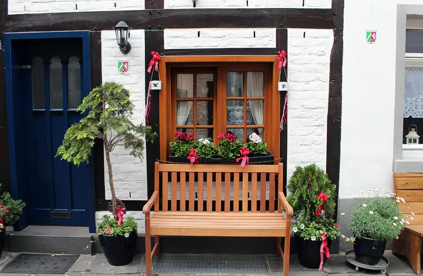 Home with blue door wood bench and flower box in window