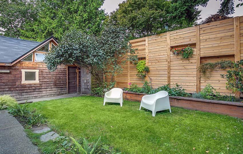 Wooden fence with plant boxes alcoves for plants in backyard