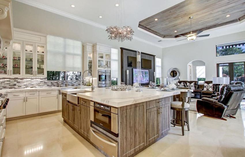 Kitchen with cream porcelain tile floors and large marble topped island with pendant light