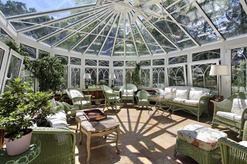 Large sunroom with sky light windows and green wicker furniture