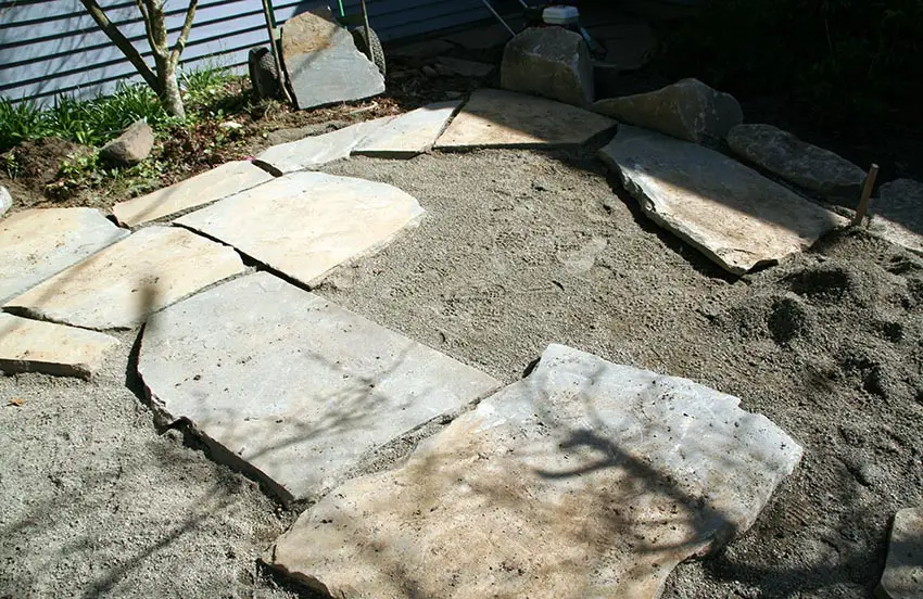 Laying flagstones to build a patio over gravel