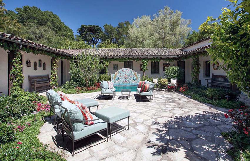 Mediterranean style patio with aqua blue tile fountain