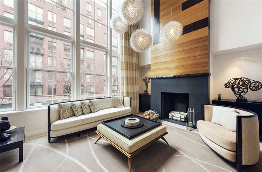 Modern zen style living room with wood accent wall fireplace, globe lighting, beige furniture and large windows 