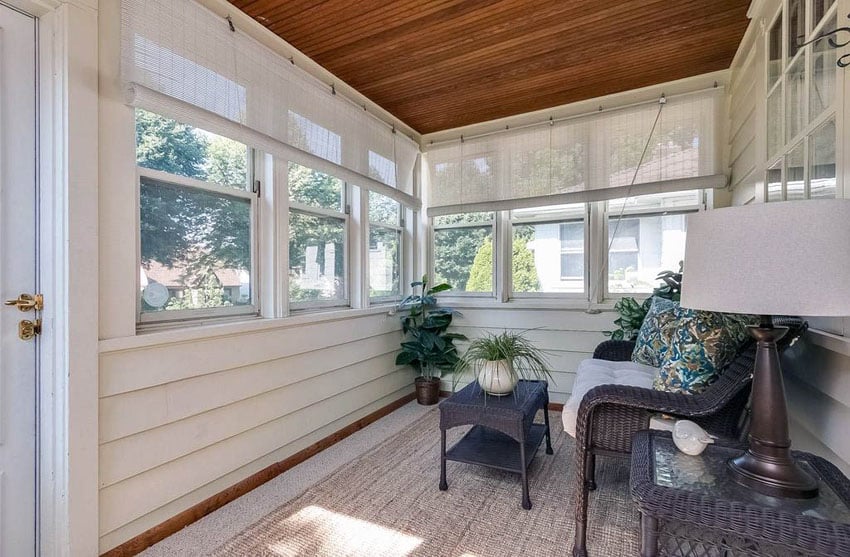 Small sunroom addition with wood siding and wood slat ceiling