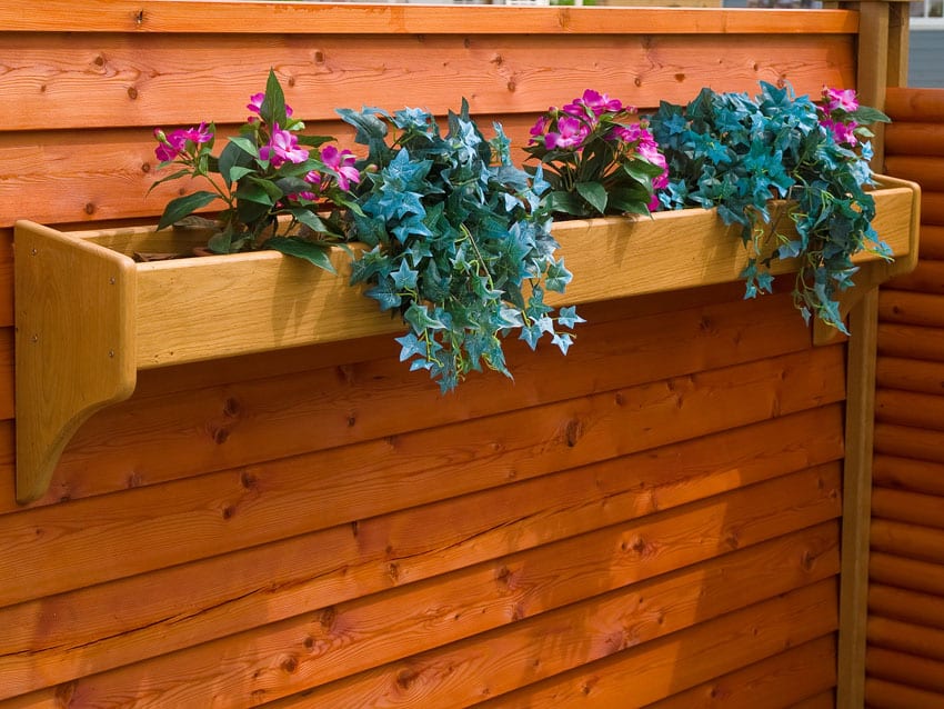 Stained wood fence with wood planter flowerpot