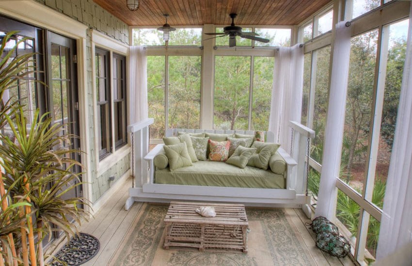 Sunroom addition with large windows and swinging loveseat