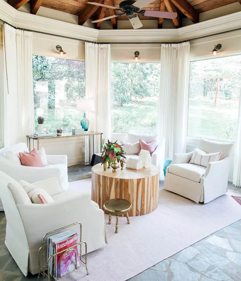 Sunroom with tall cathedral ceiling and white furniture