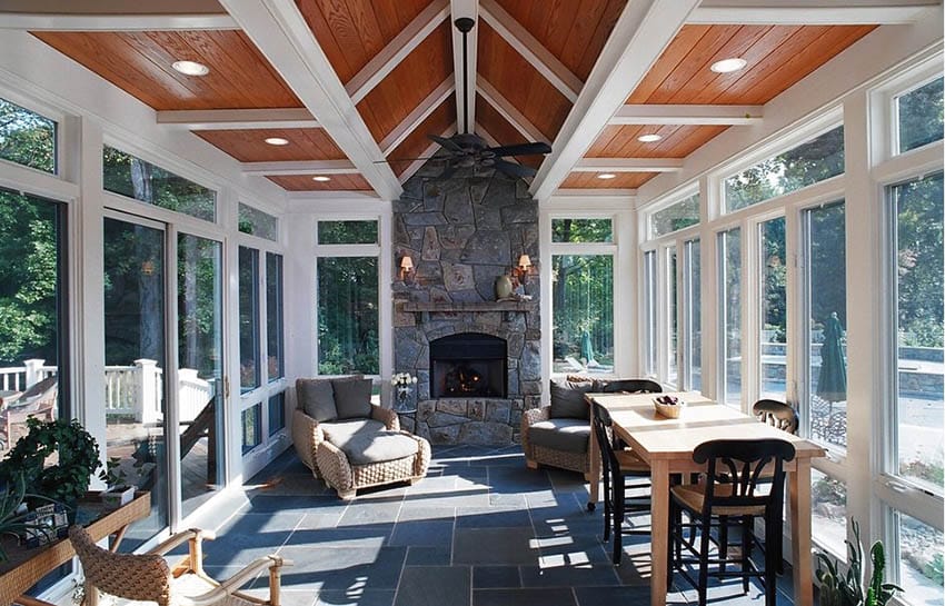 Sunroom with high ceiling, stone fireplace and slate floors