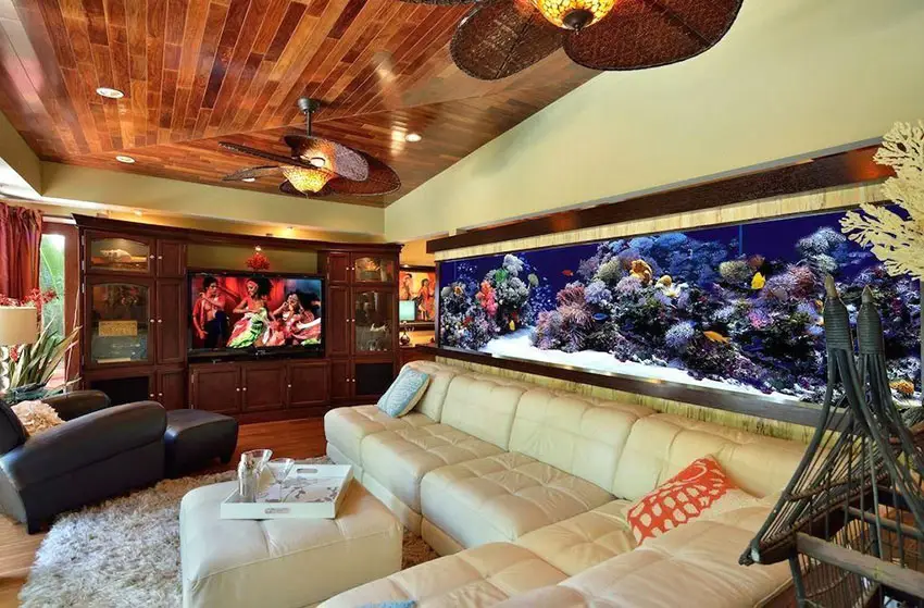Tropical living room with cream leather sectional couch and large saltwater aquarium