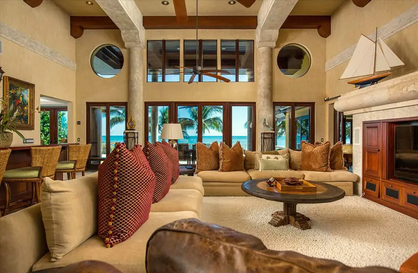 Tropical themed living room with high ceiling concrete pillars and built in wall console