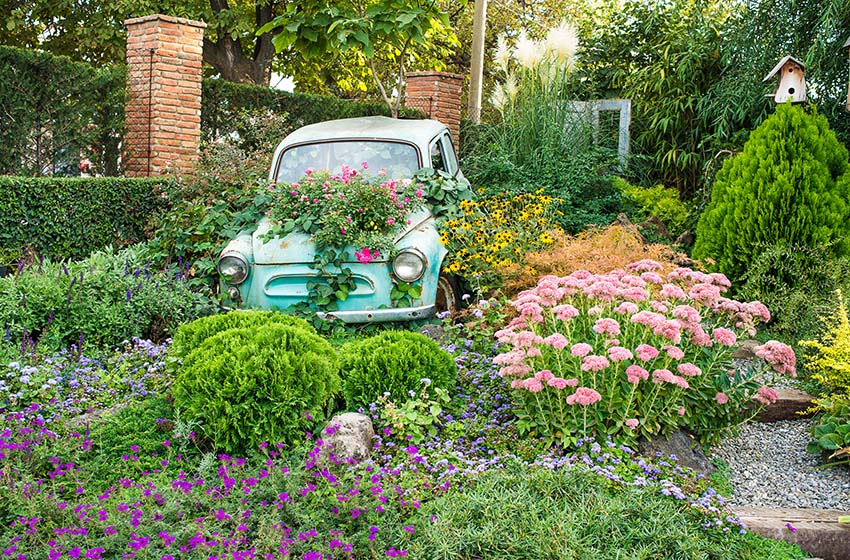 Vintage old car as flower box in garden