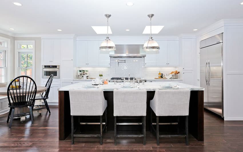 White contemporary kitchen with calcatta marble countertops, dark wood island and hardwood floors