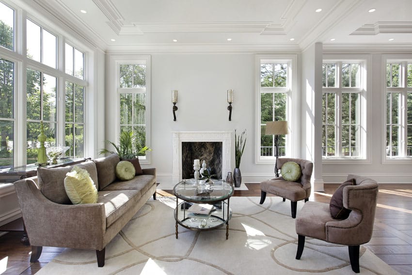 White sunroom with fireplace and comfortable brown furniture