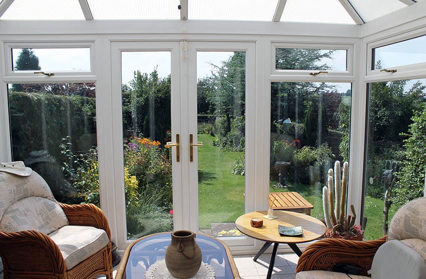 White sunroom with views of garden