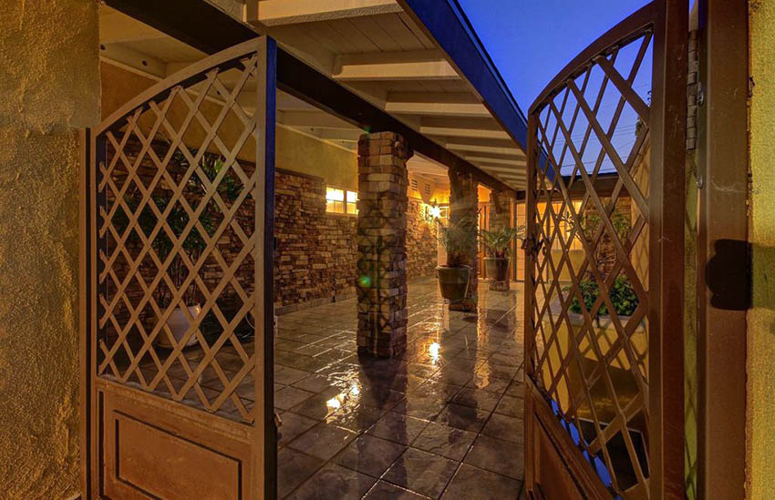 Wood lattice gate leading to backyard with polished concrete floor