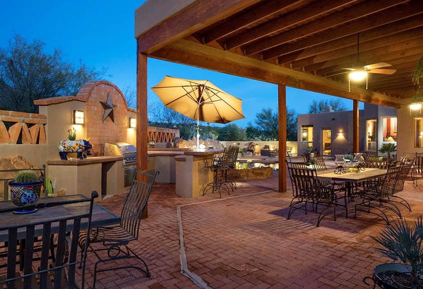 custom pergola with wooden canopy over brick patio and outdoor kitchen
