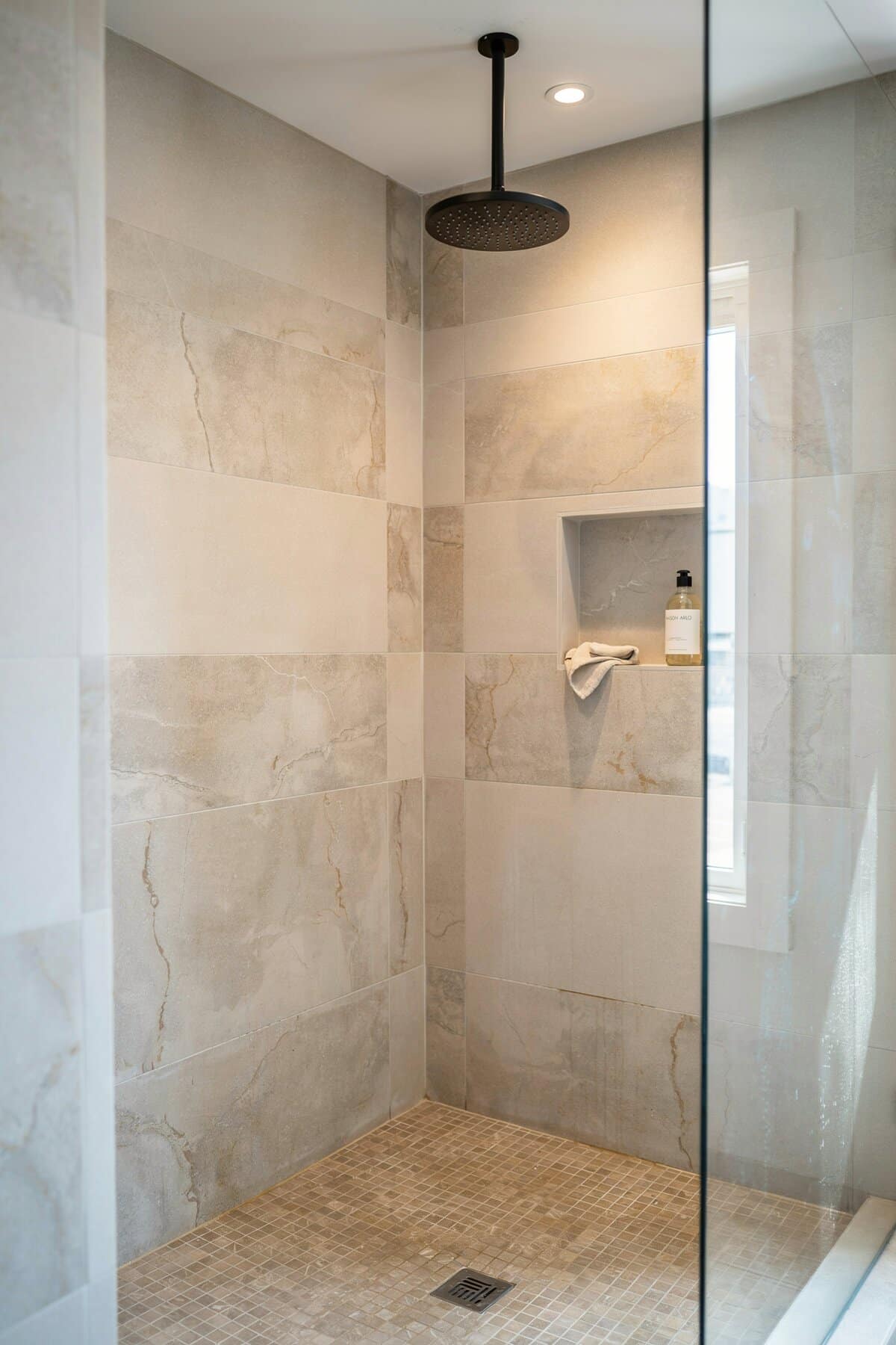 Mosaic tile flooring, recessed lighting and modern showerhead
